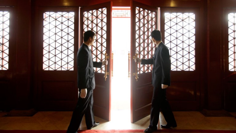 Waiters open a Chinese traditional red door inside a luxurious furniture museum in Beijing February 5, 2010