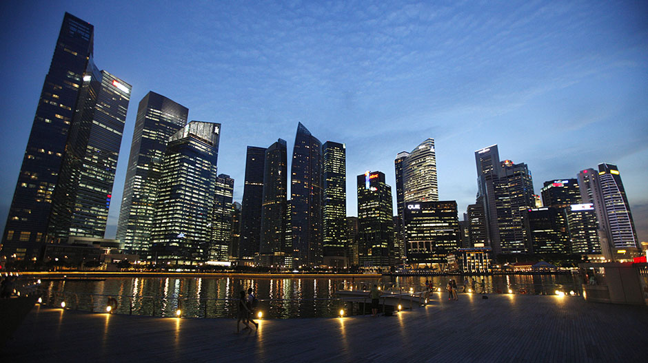 People walk past the skyline of Marina Bay central business district in Singapore April 26, 2013.